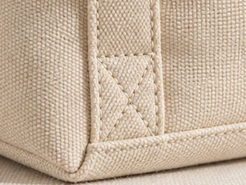 Close-up of the stitched base corner and handle seam of the tote