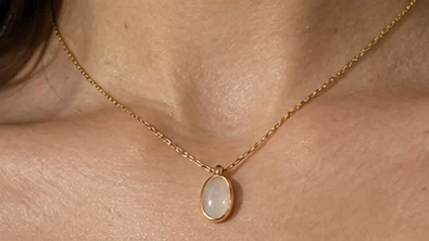Close-up of the pendant resting below the collarbone
