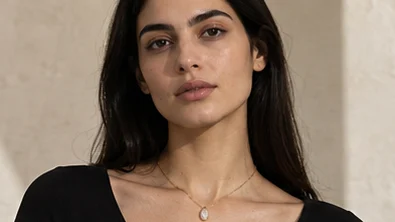 Gold pendant necklace worn by a model, front portrait