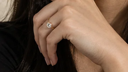 Close-up of the solitaire ring on the finger, hand raised